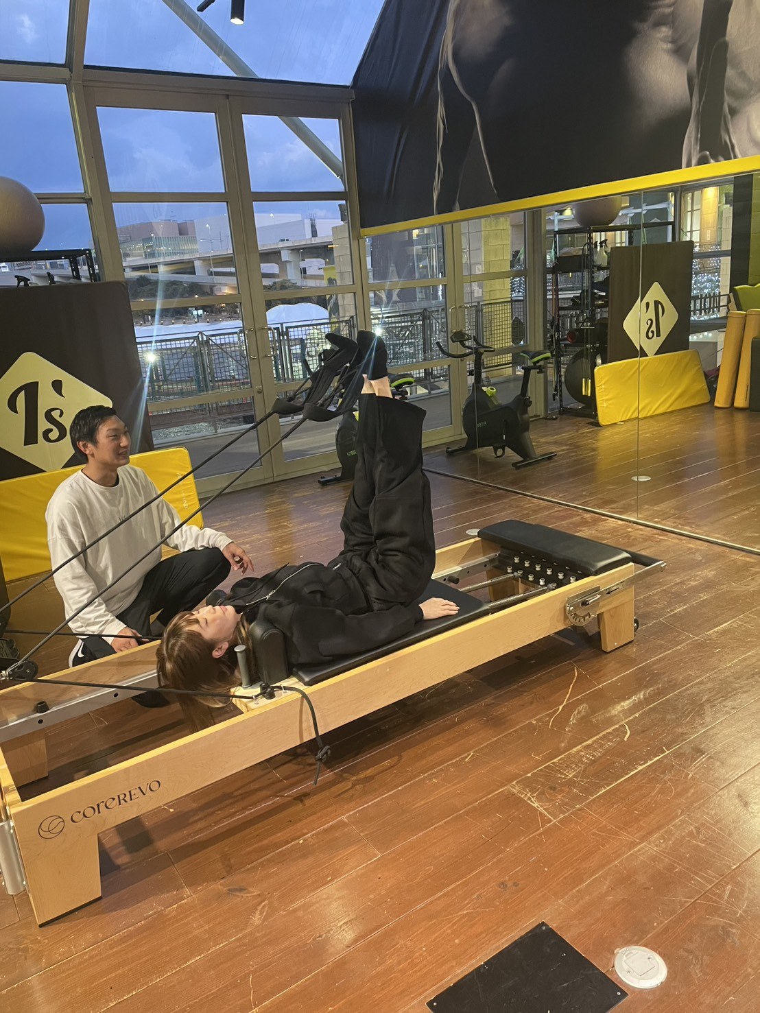 トレーナーが女性のお客様に運動指導をしている様子